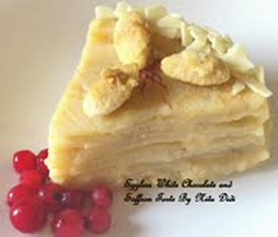 An eggless dessert made with layers of crepes and white chocolate custard, decorated with nuts and fruit on the side